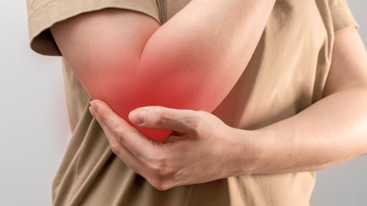 image of a woman holding her painful elbow