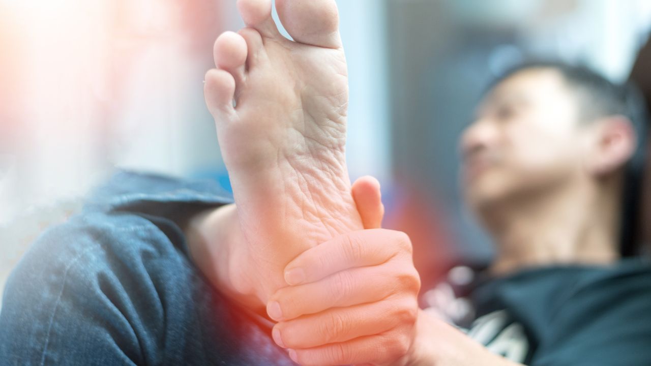 image of a man holding his heel in pain