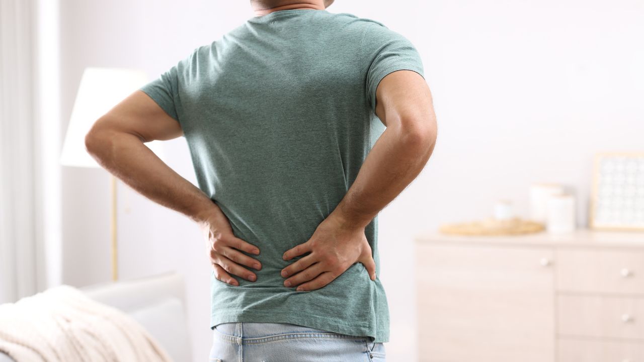 image of a man holding his back in pain