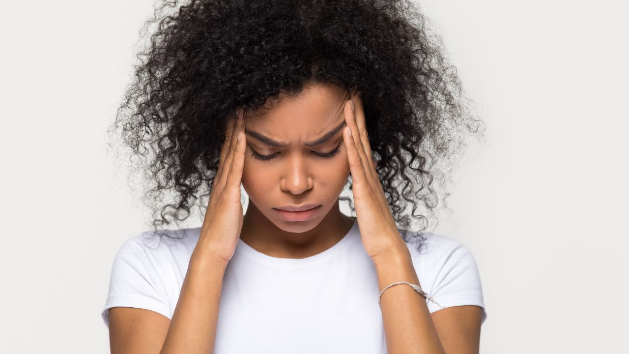 image of woman with headache pain holding her head