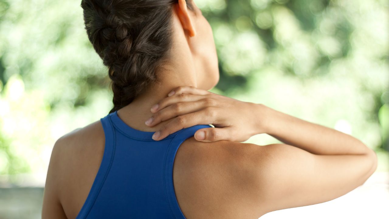 image of a woman in pain touching the back of her neck