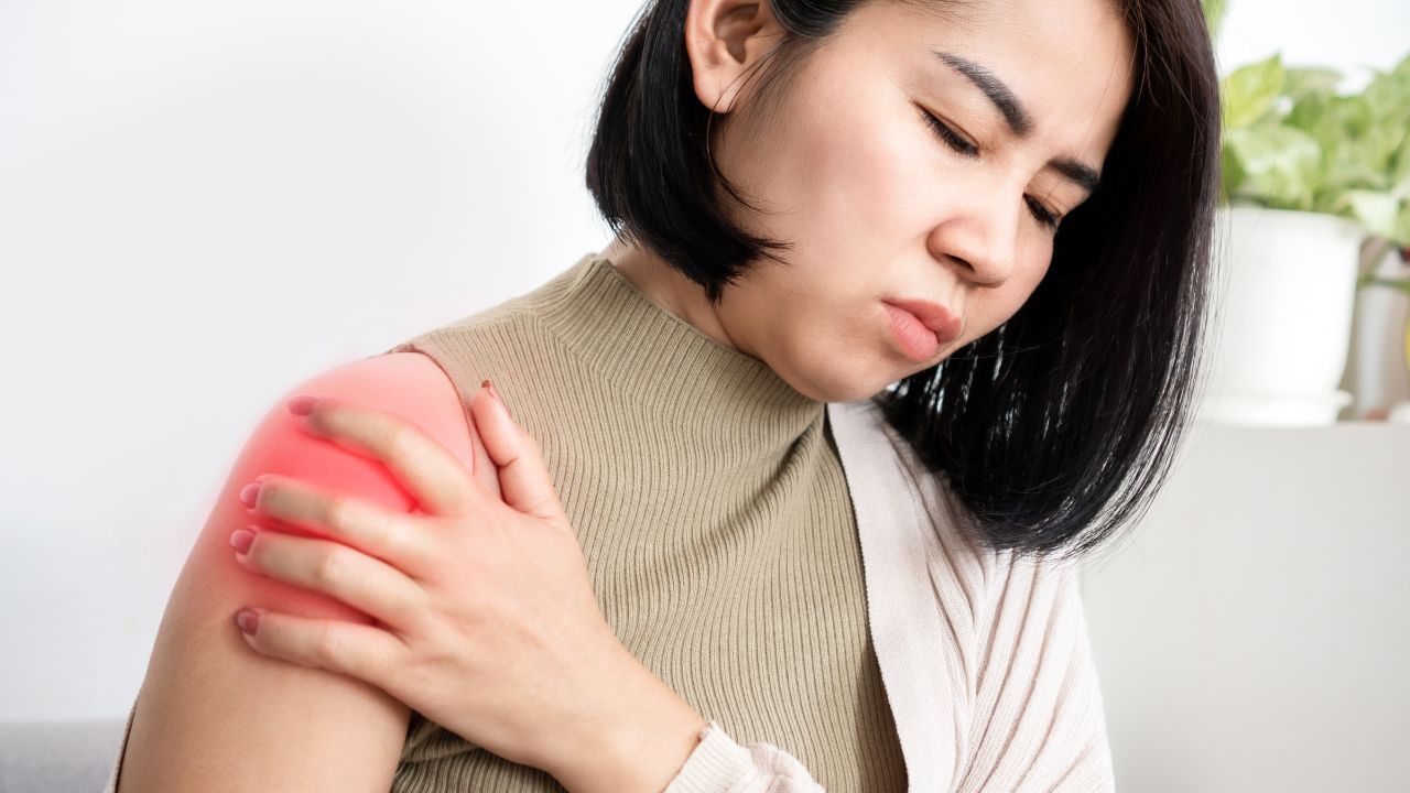 image of a woman in pain holding her shoulder